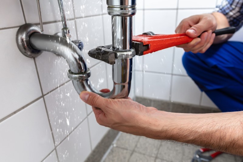 Plumber checking residential plumbing for a possible leak
